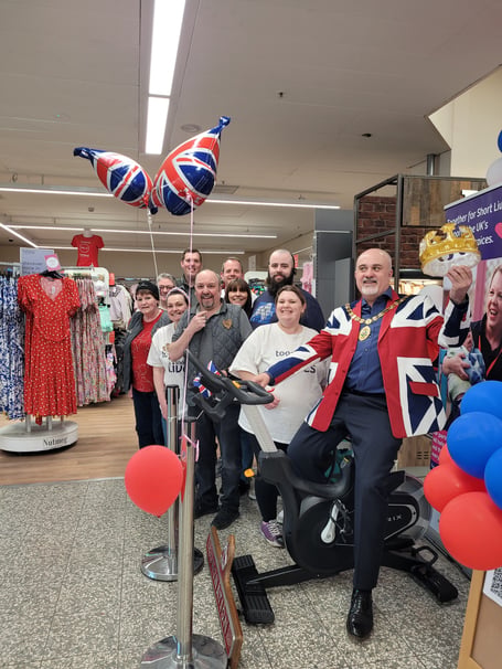 Cllr Ed O'Driscoll on a spin bike in Morrisons, Ross-on-Wye