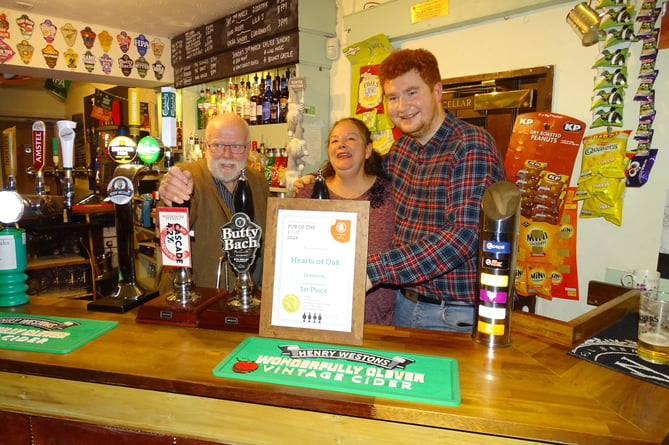 Tom and Sarah are presented with the certificate for Forest of Dean CAMRA Pub of the Year 2024. (with some bloke called Geoff Sandles, chair of Forest of Dean CAMRA, photo-bombing the picture!