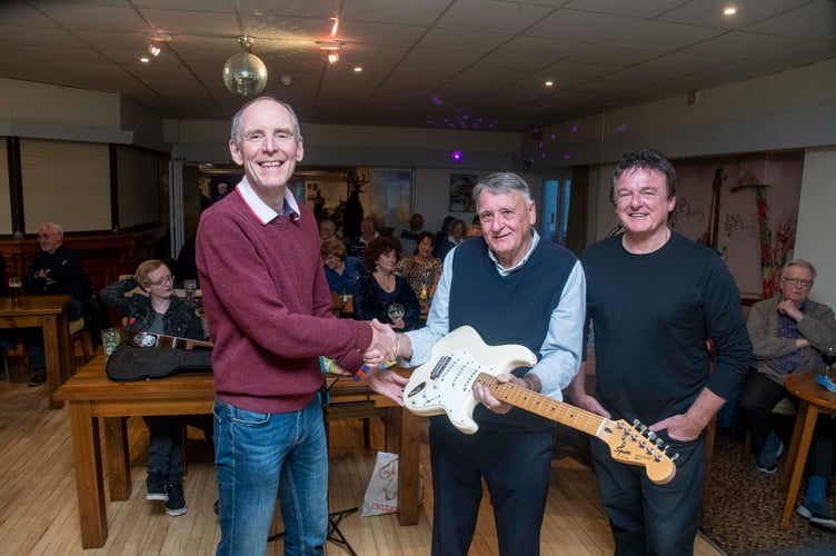 Barry Carlino (left) is presented with the Fender Stratocaster by John Ozaroff (right) and chairman of The Club Rodney Welsh