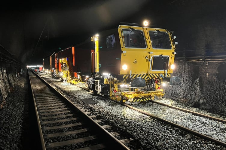 A tamping machine levels the ballast.