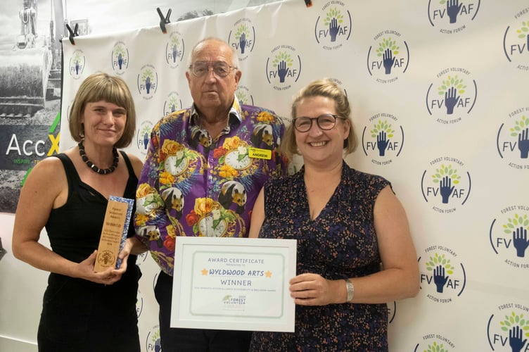Sarah Wyatt of Wyldwood Arts and Lucy Ellis-Howell receive the accessibility and inclusion award from Andy Morgan-Watts of the Forest Dementia Action Alliance.