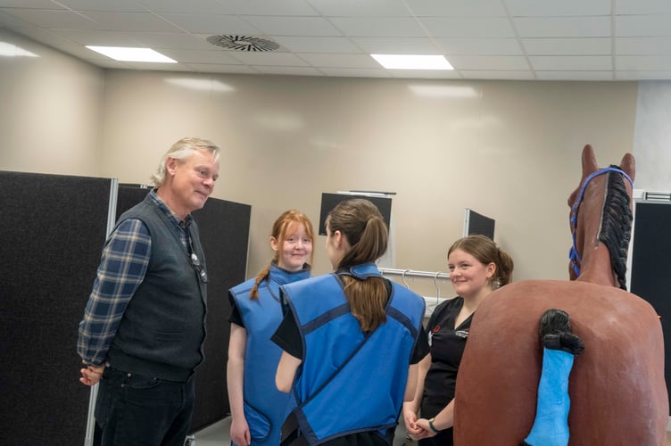 Martin Clunes hears how an x-ray is taken from Abi Evans (left) and Libby Waters (right).