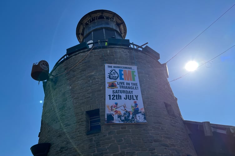 A banner announcing EMF at CindyFest is unveiled on the clock tower.