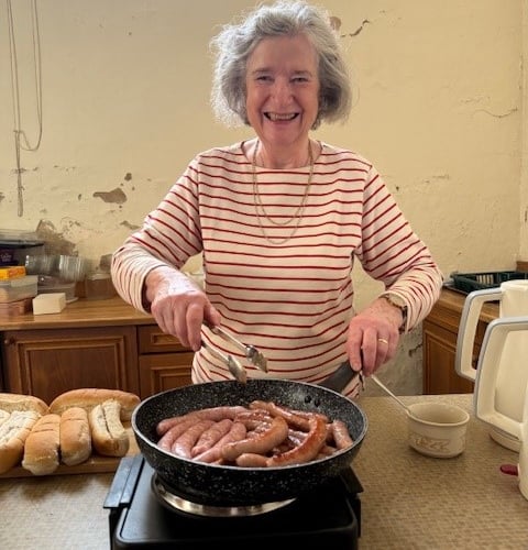 Churchwarden Carryl Phelps cooking Hot Dogs as payment