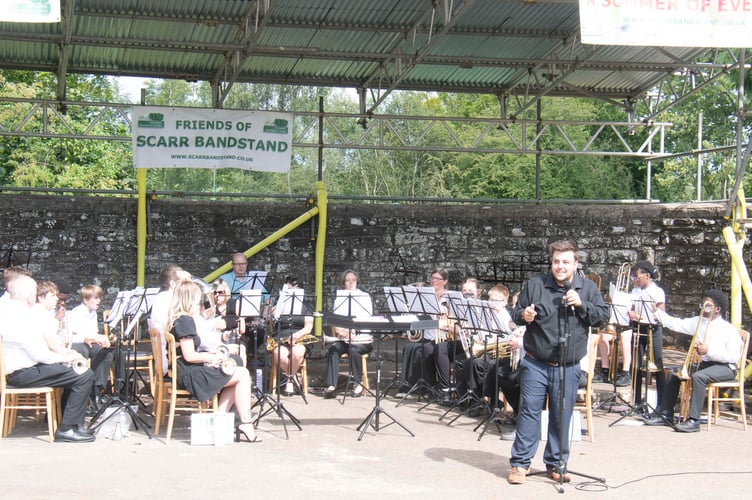 Cinderford conductor Joey Prescott challenges the audience to name the tunes in the Disney medley the band had played.