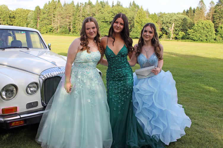 Three friends pose in front of a vintage Daimler.