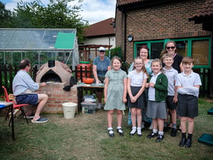 Kids enjoy pizza from oven they built
