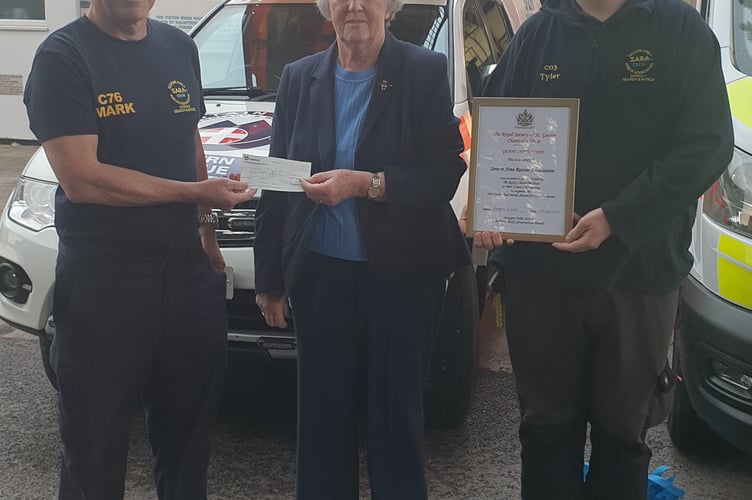 Royal Society of St George branch secretary Margaret Fuller and Tyler Carpenter present a cheque to Mark Powell, SARA's site manager at Beachley.