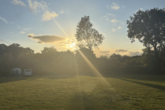 Views across the grass pitches as the sun sets over the Forest of Dean.