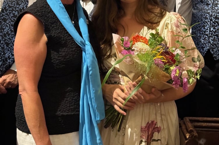 Eleanor Cook (left) presents flowers to Kirsten Barker.