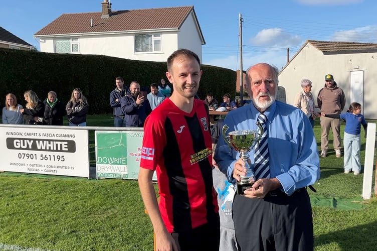 Milkwall captain Lee Roberts is presented with the West Dean Intermediate Cup by the Charities' former treasurer John Barrett.