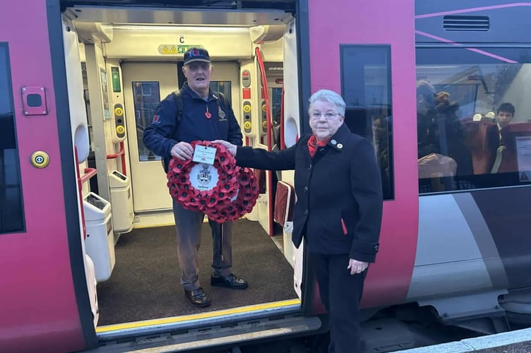 Lydney town councillor Carol Harris hands Mel Rudge the wreaths for Poppies to Paddington at Lydney station.