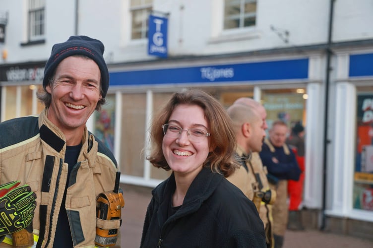 A firefighter and volunteer manage a smile 
