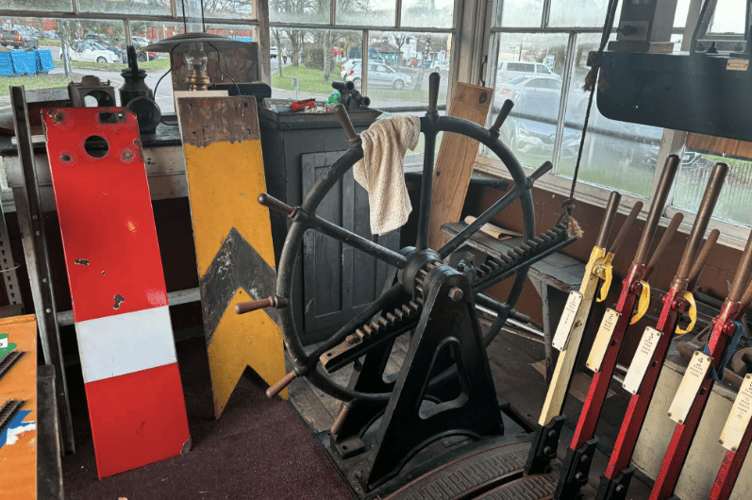 An old level crossing wheel and traditional signal levers on display at the museum.