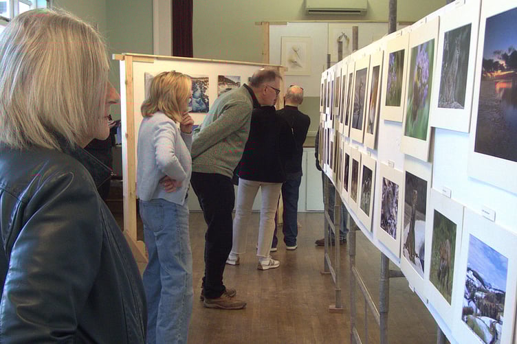 Visitors enjoy viewing the photographs on show during the Clearwell exhibition organised by four members of the Forest of Dean Camera Club.