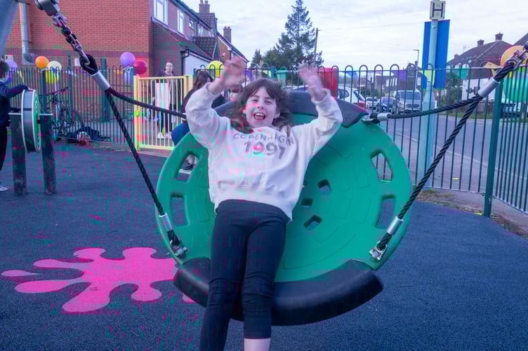 Millie Phillips tries out the larger bucket swing for size.