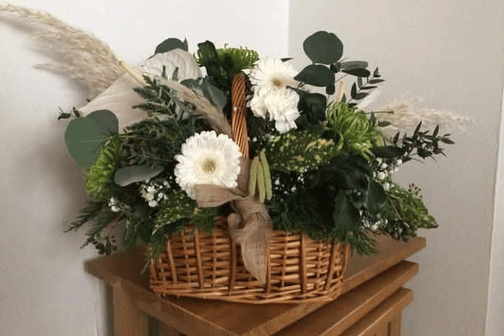 Flowers & Gifts by LauraJane presents a vibrant hanging flower basket bursting with seasonal colour, perfect for gardens and business frontages.