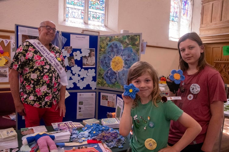 Charlie and Alex Bell and Andy Morgan Watts of the Forest Dementia Action Alliance with knitted forget-me-nots at the launch event at The Wesley.