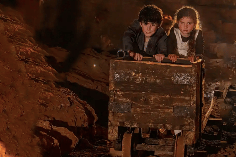 Two young models push a traditional mine cart as photographers recreated scenes inspired by the Forest of Dean's mining heritage.