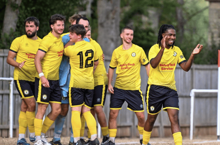 Newent Town celebrate after their dramatic penalty shootout victory over Almondsbury in the FA Vase First Qualifying Round at Wildsmith Meadow.