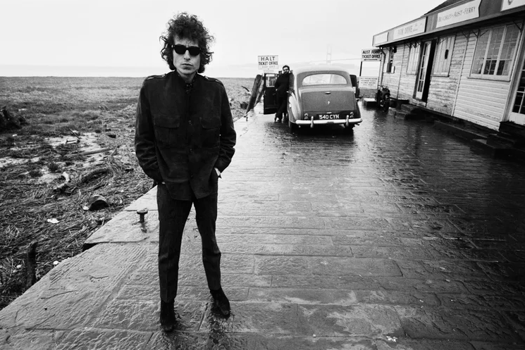 Bob Dylan waits at the Aust Ferry terminal in May 1966 while travelling from Bristol to Cardiff, with the nearly completed Severn Bridge behind him. The ferry to Beachley closed when the new crossing opened later that year.
