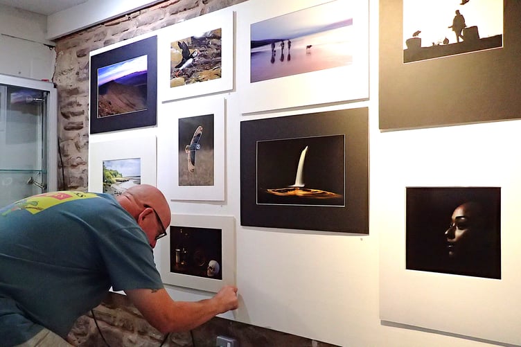 A Forest of Dean Camera Club member helps arrange photographs ahead of the opening of the ‘Your World-Our Eyes’ exhibition at the Dean Heritage Centre.
